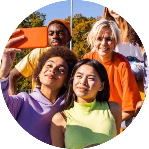 Image of a diverse group of high schoolers grouping together to take a selfie in the sun.